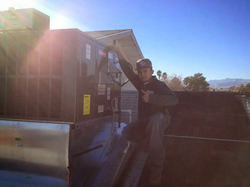 HVAC technician performing Boiler Repair on a rooftop unit in Elkhorn